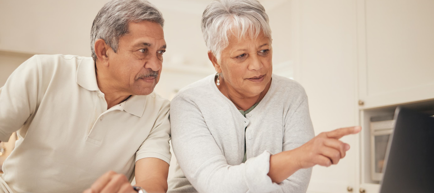 A photo of a senior couple looking at a laptop