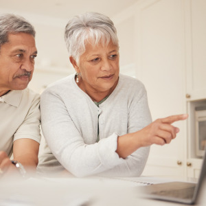 A photo of a senior couple looking at a laptop