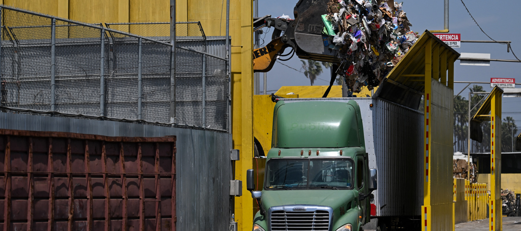 Garbage is transferred to a truck at a waste management center.