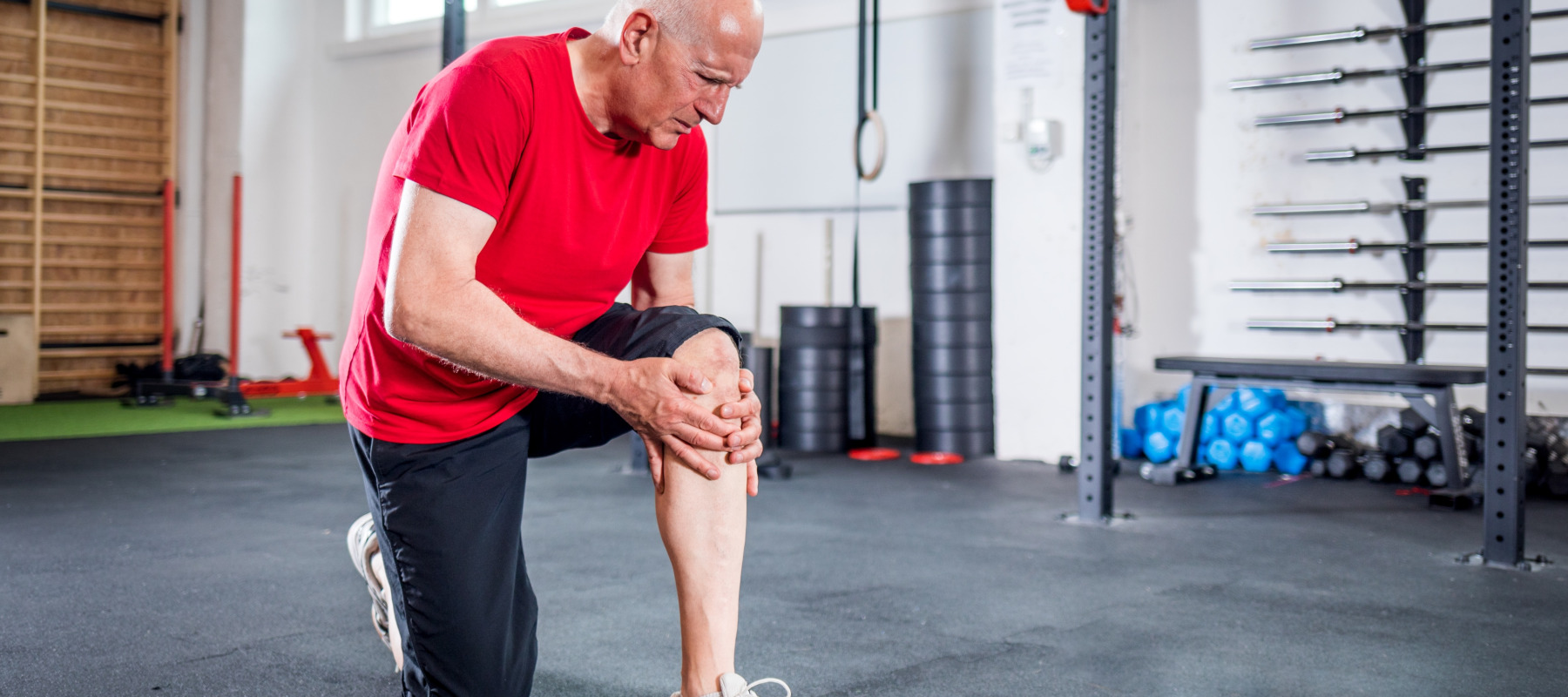 man in gym holding knee