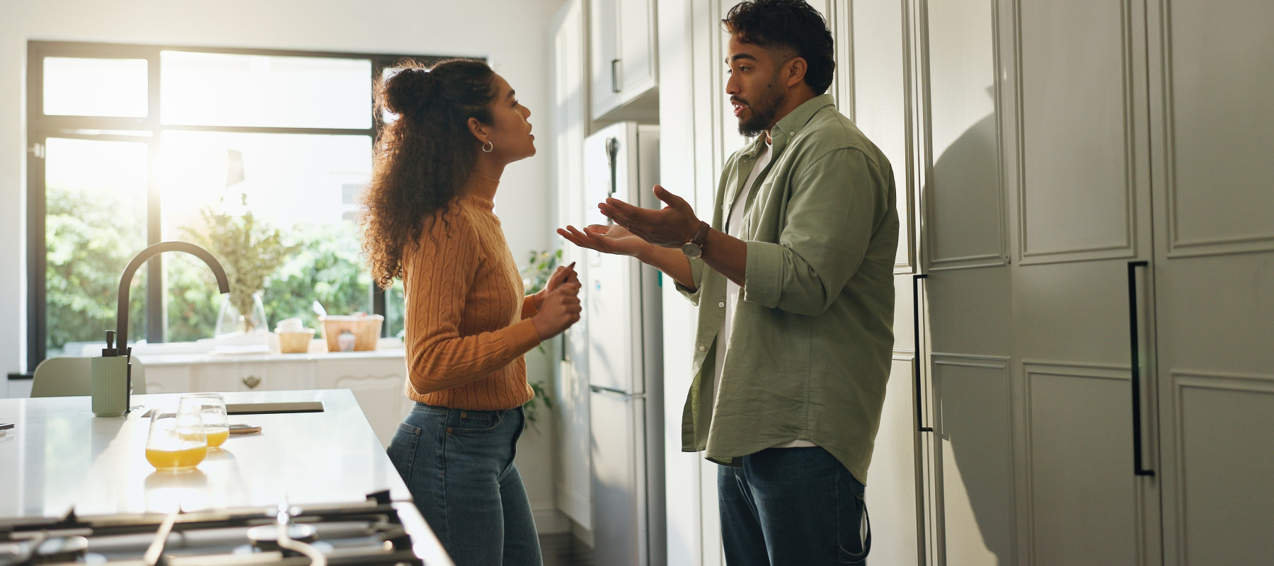 A couple arguing in the kitchen of their home.