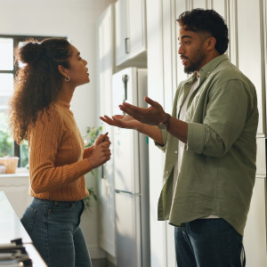 A couple arguing in the kitchen of their home.