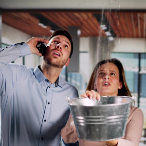 Couple on the phone with their insurance company after a roof leak.