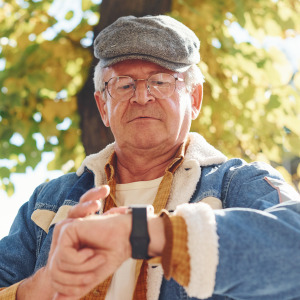 An older man looks at his watch.
