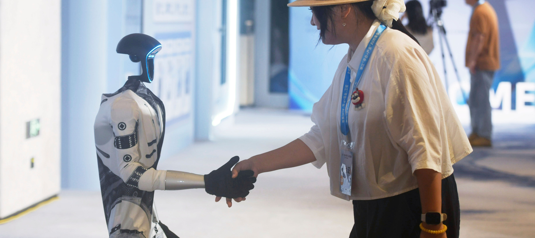 Someone shaking hands with a G1 humanoid robot from Unitree Robotics.