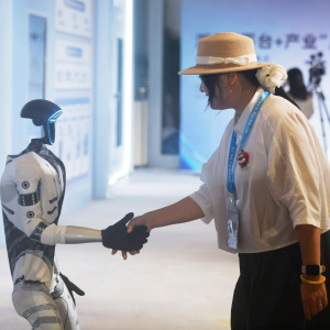 Someone shaking hands with a G1 humanoid robot from Unitree Robotics.