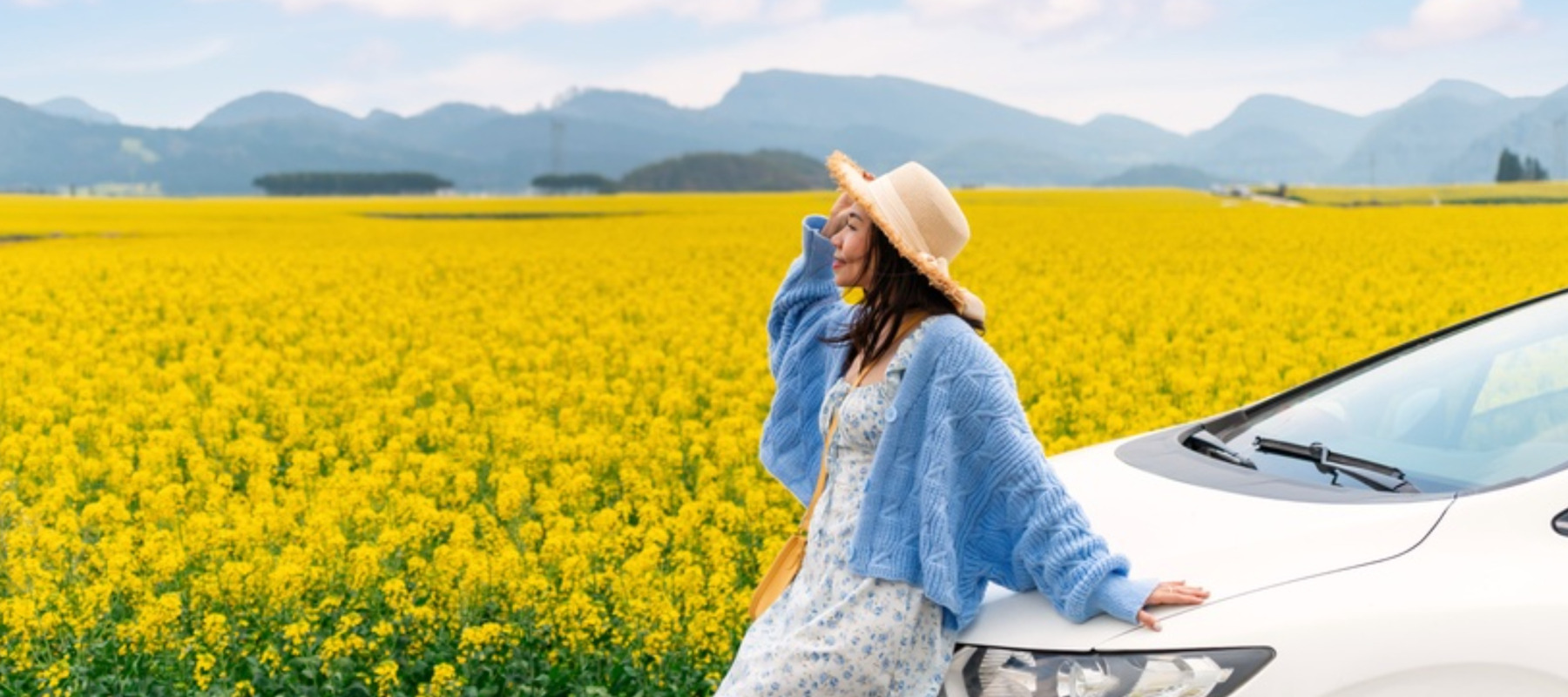 Happy young woman enjoying the canola fields while traveling to Luoping County in China