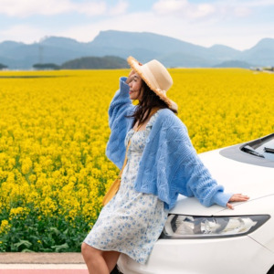 Happy young woman enjoying the canola fields while traveling to Luoping County in China