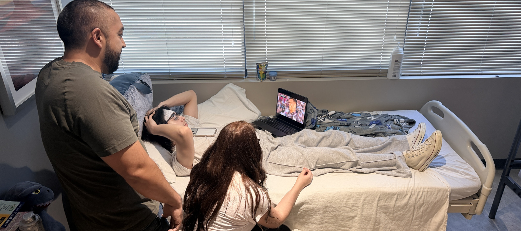 Axeel Melendez recovers in his hospital bed with loved ones at his side.