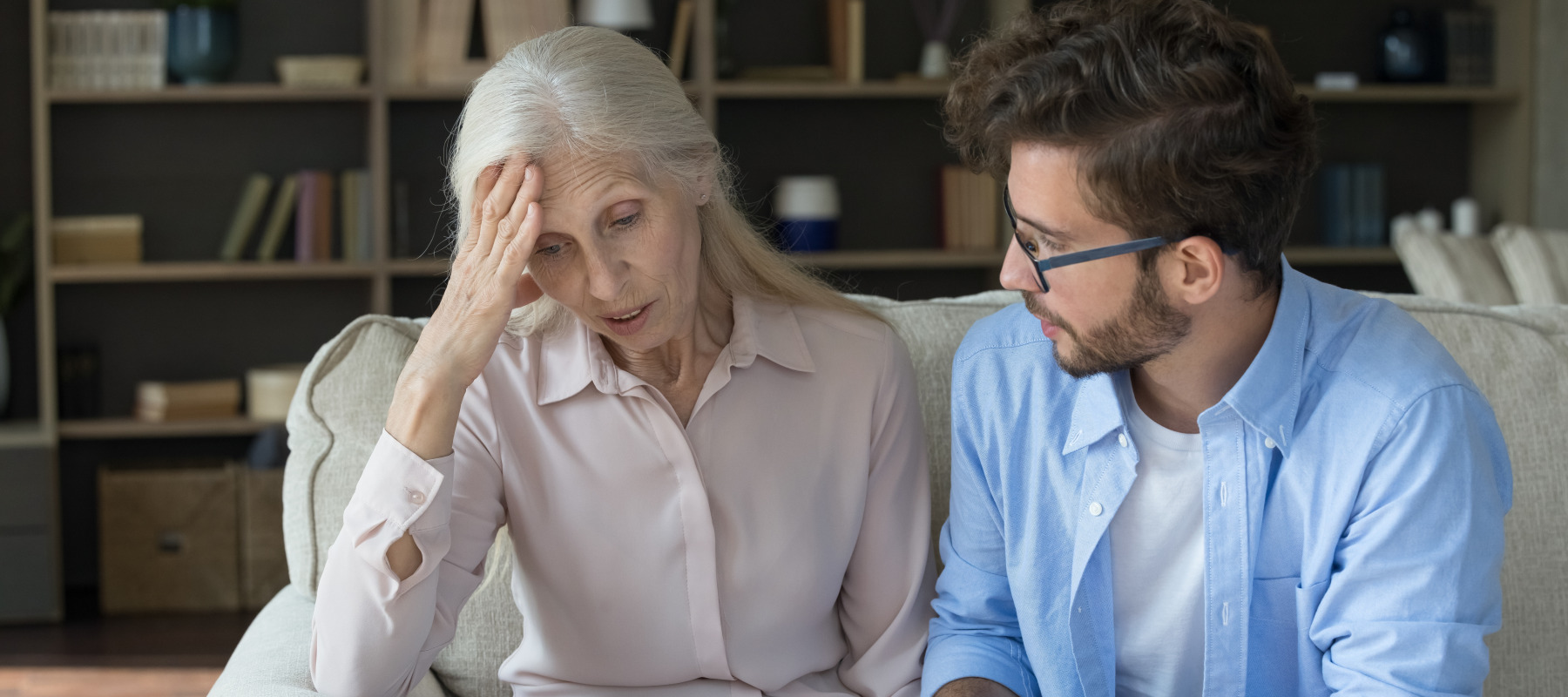A man comforts a distressed older woman.