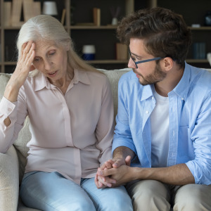 A man comforts a distressed older woman.