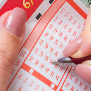 Photo of a woman's hands filling out lottery ticket