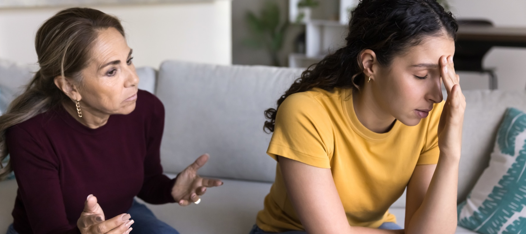 Mother and daughter arguing on the couch.