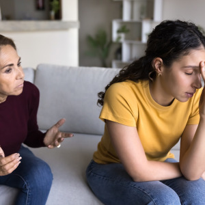 Mother and daughter arguing on the couch.
