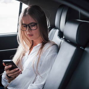 A photo of a woman sitting in the back seat of a car