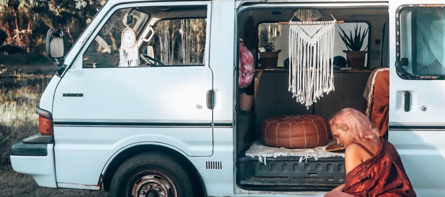 A photo of a woman cooking outside a campervan
