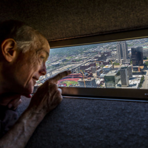 Man looks out window at top of Gateway Arch over St. Louis.