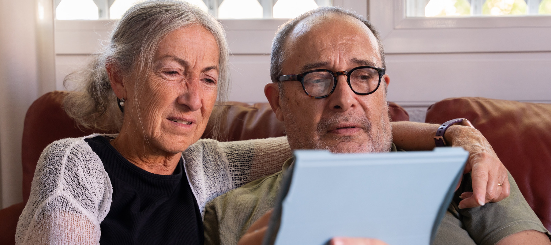 Older retired couple frustrated and looking for something online.