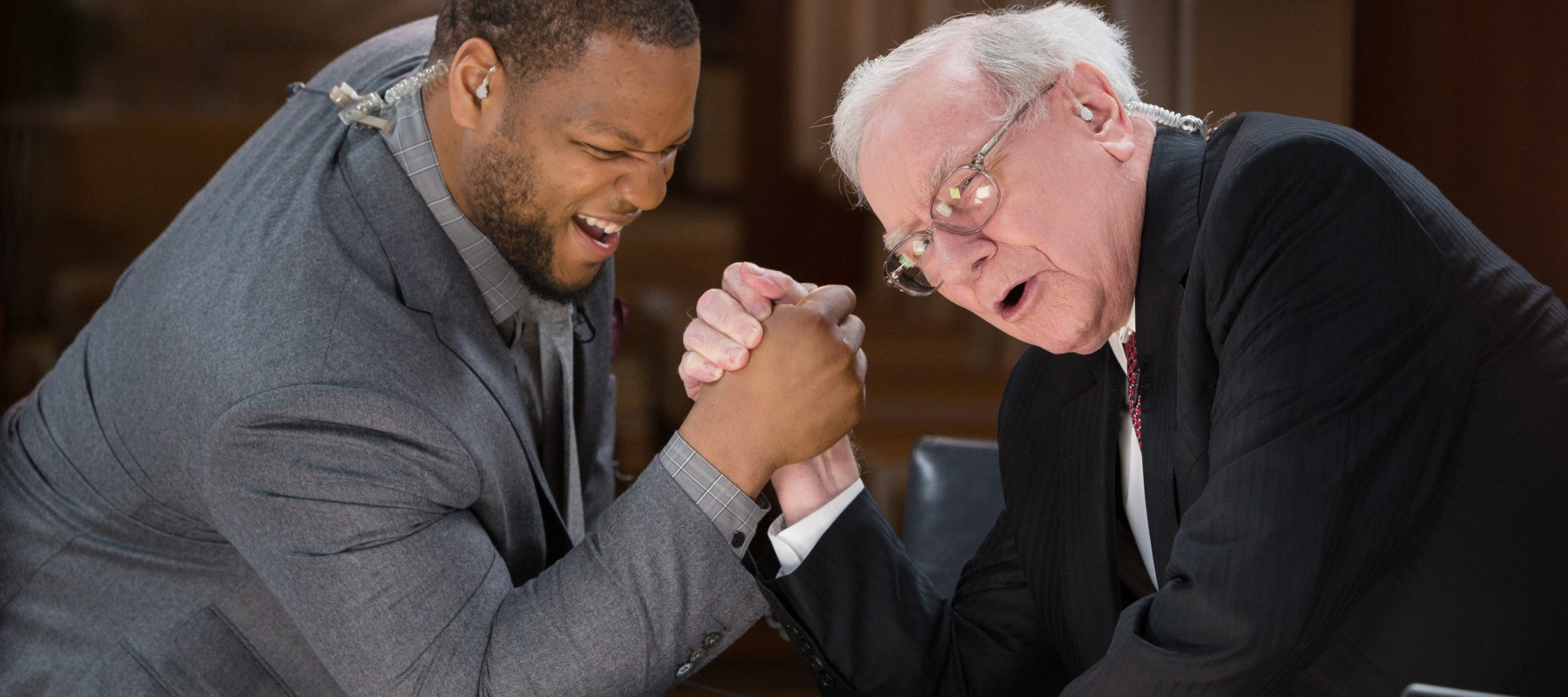 Former Detroit Lions' defensive tackle Ndamukong Suh arm wrestles with Warren Buffett, former CEO of Berkshire Hathaway.