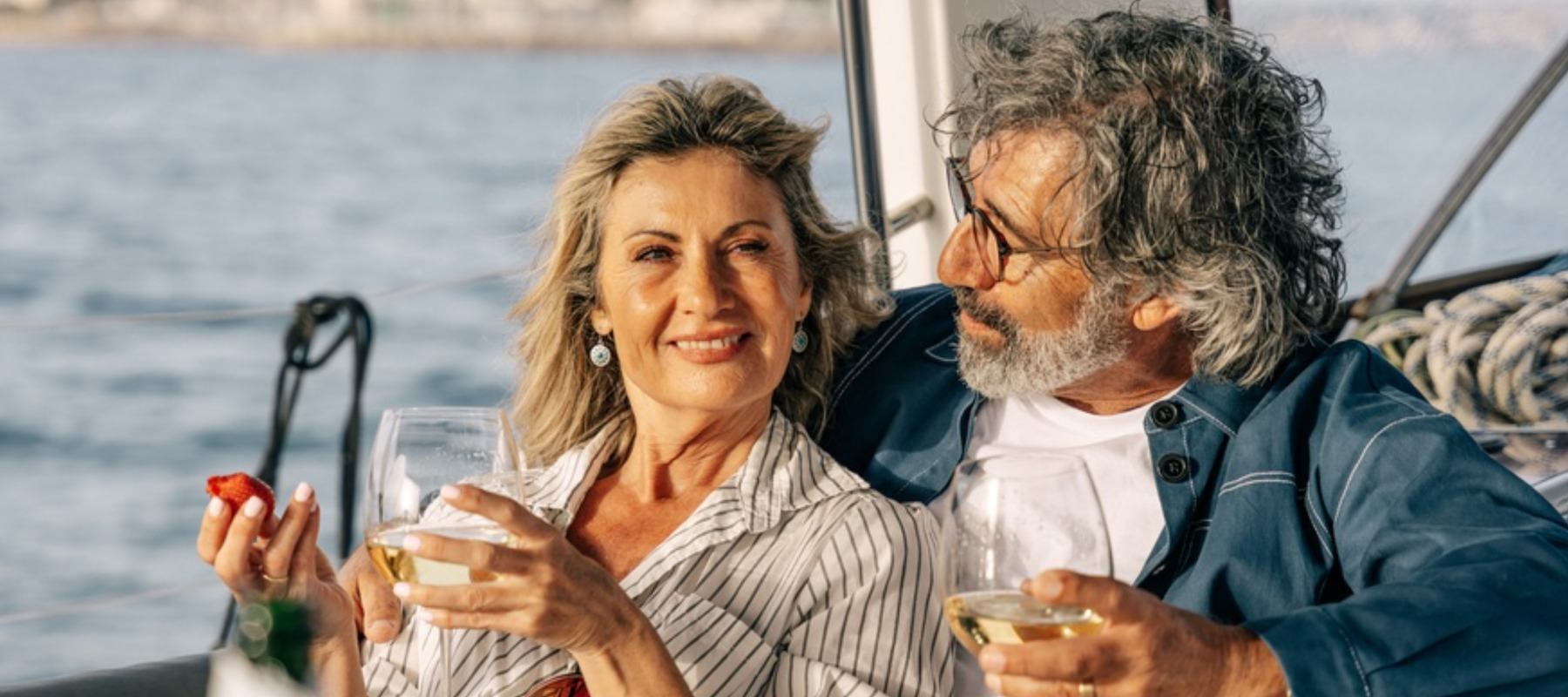Photo of older couple having fun and drinking wine on a boat