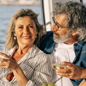 Photo of older couple having fun and drinking wine on a boat