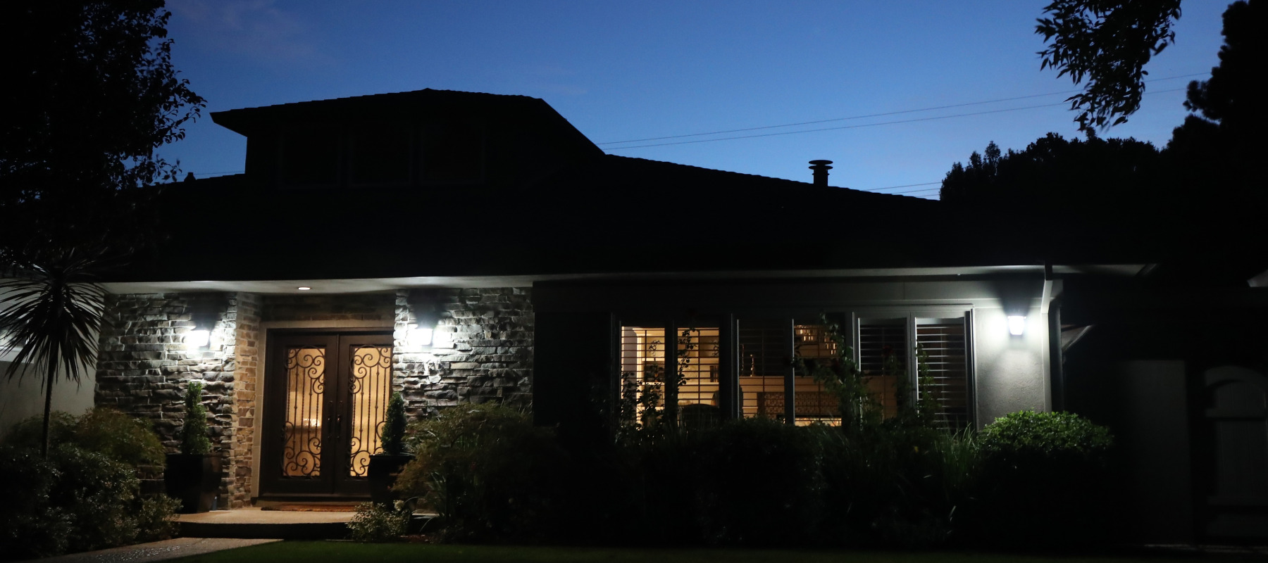 Bungalow home in San Jose, California seen from outside at night.