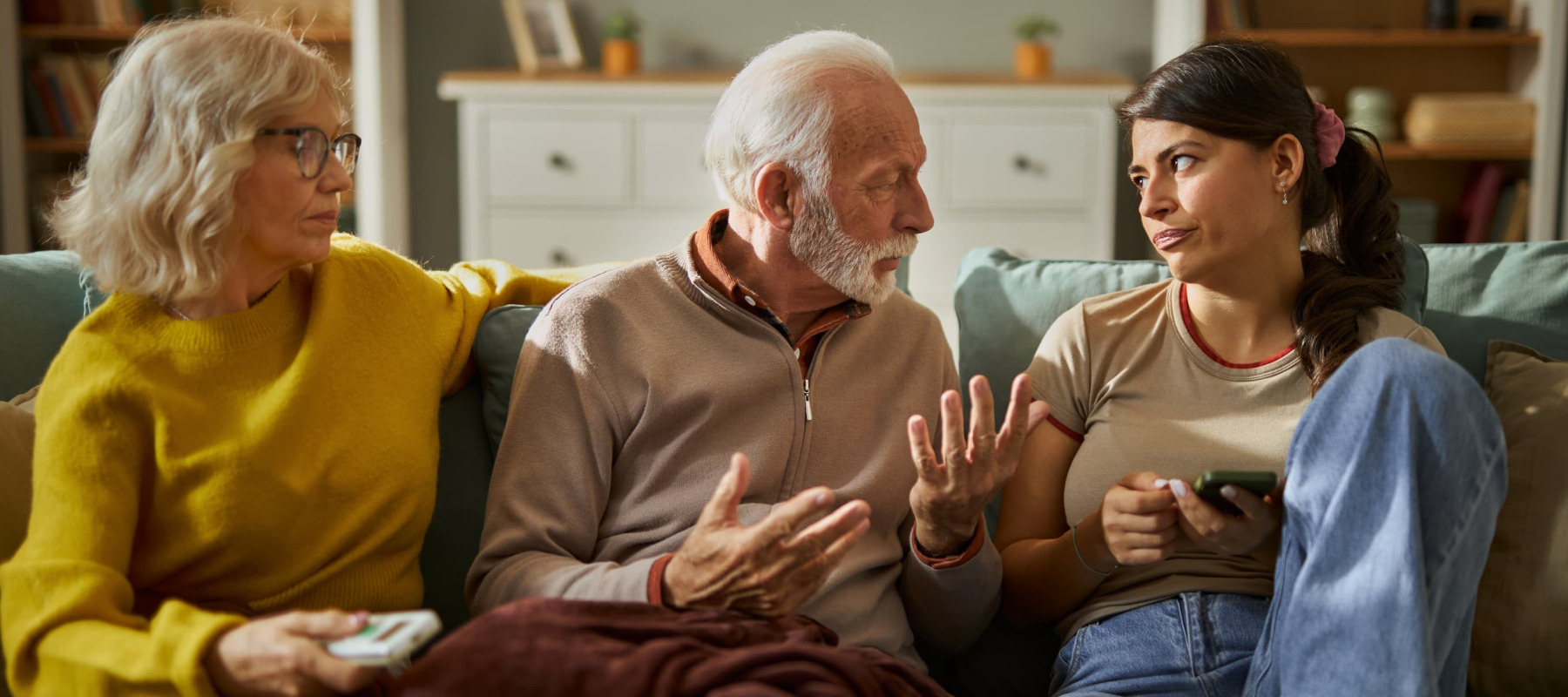 A photo of parents and adult daughter talking