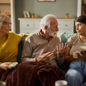 A photo of parents and adult daughter talking
