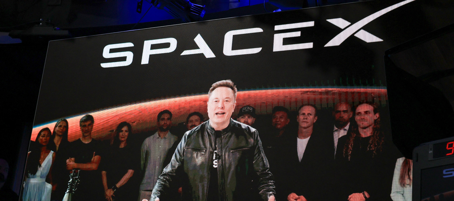 SpaceX CEO Elon Musk, displayed on a screen remotely from SpaceX headquarters in Starbase, Texas, speaks before the launch of SpaceX's initial public offering (IPO).