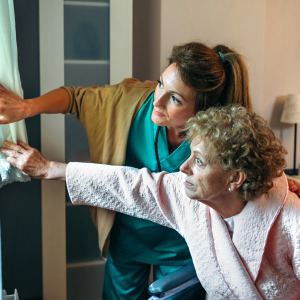 Female caregiver taking care of elderly woman