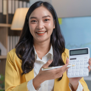 Photo of a smiling woman with a calculator