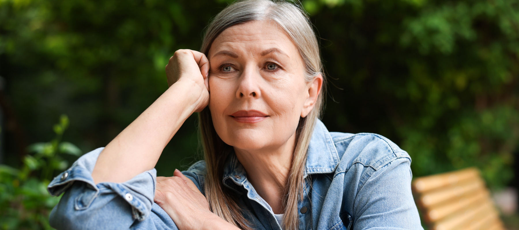 Photo of a pensive older woman sitting on a bench