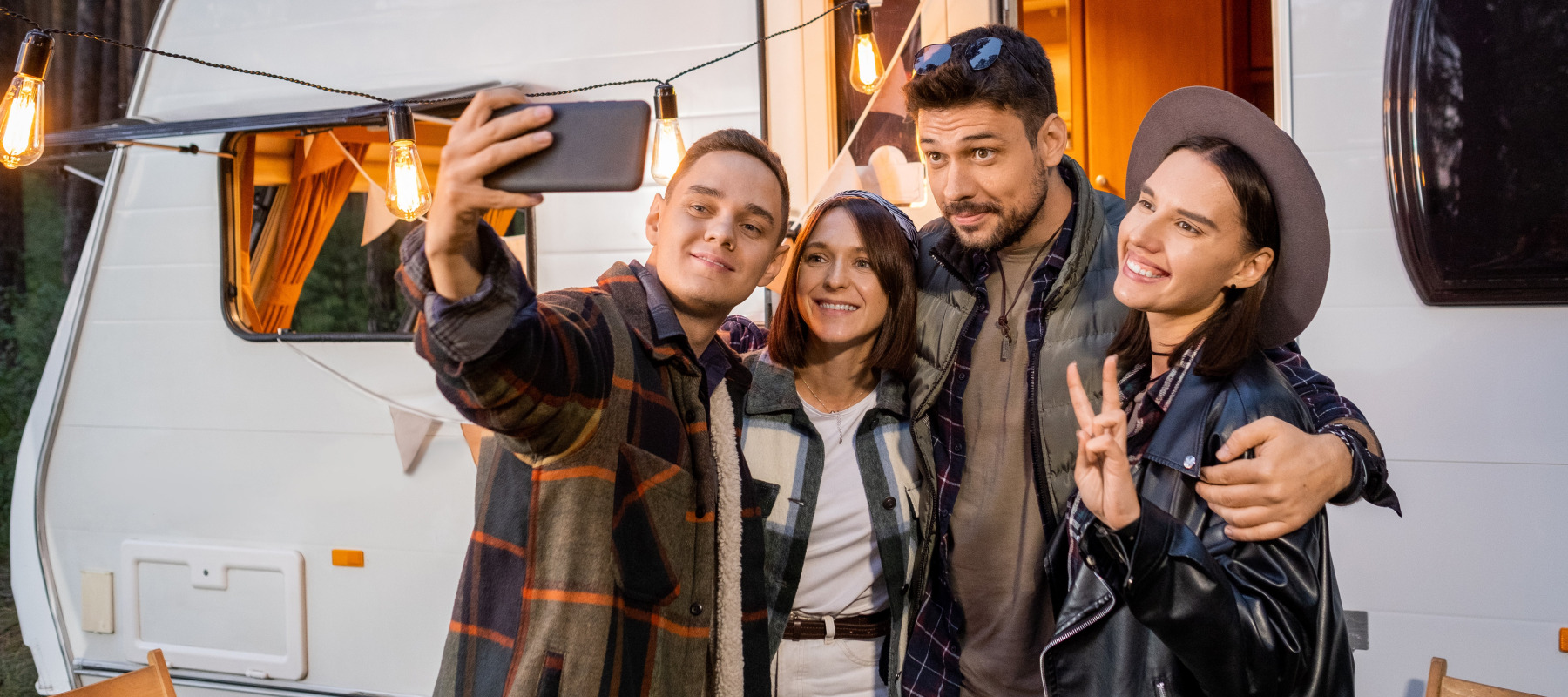 Group of people taking selfie in front of motorhome