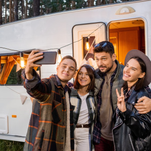 Group of people taking selfie in front of motorhome