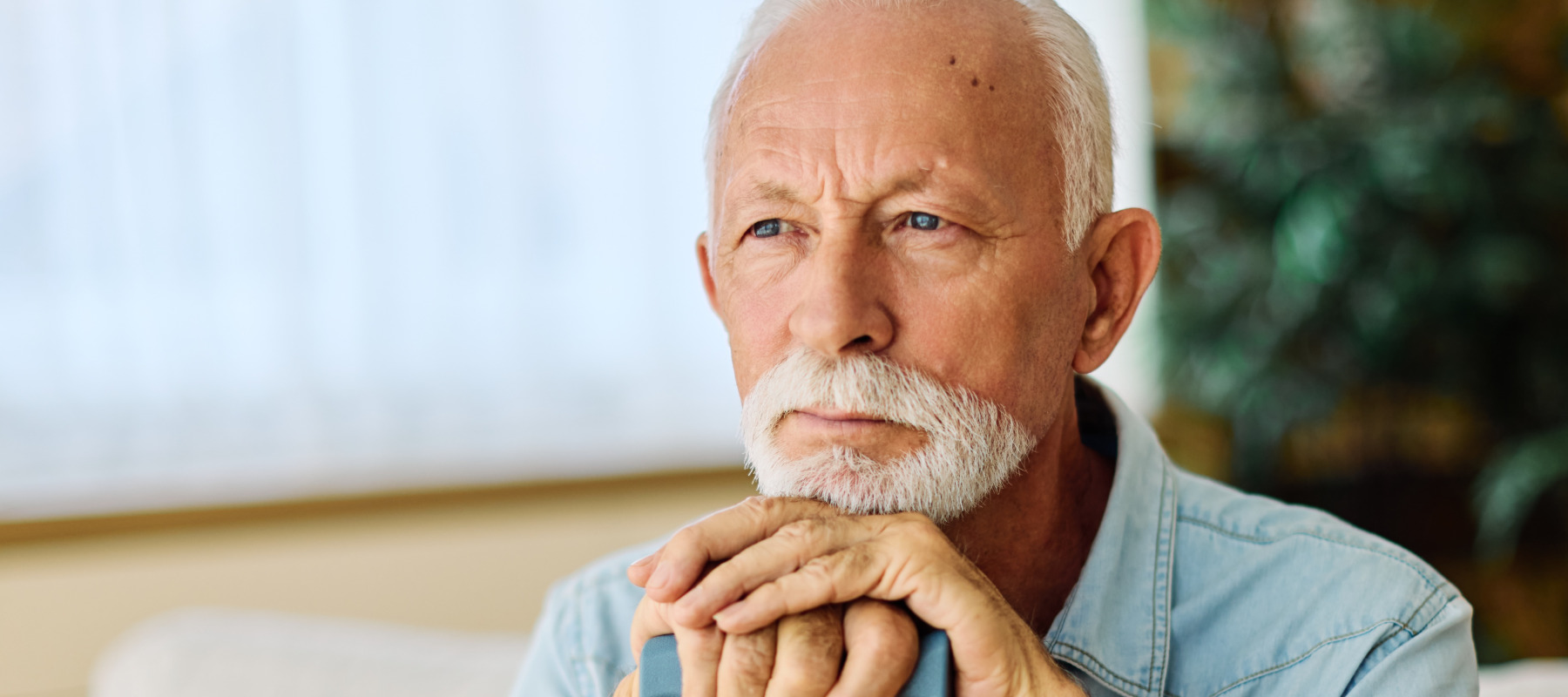 Portrait of a serious sad mature old man at home.