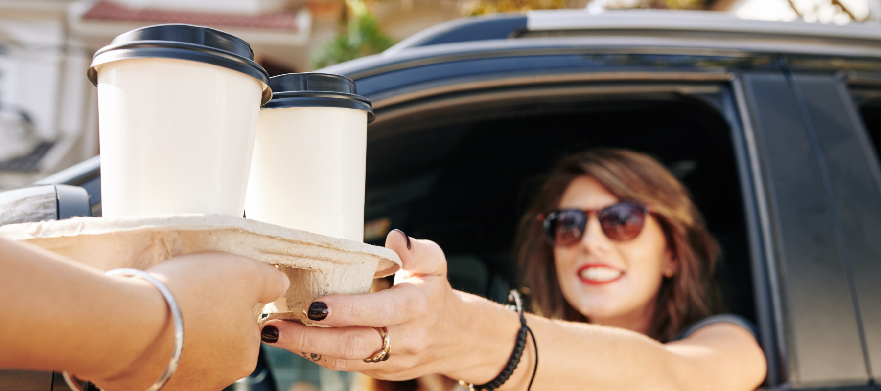 Woman purchasing coffee in drive thru