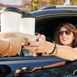 Woman purchasing coffee in drive thru
