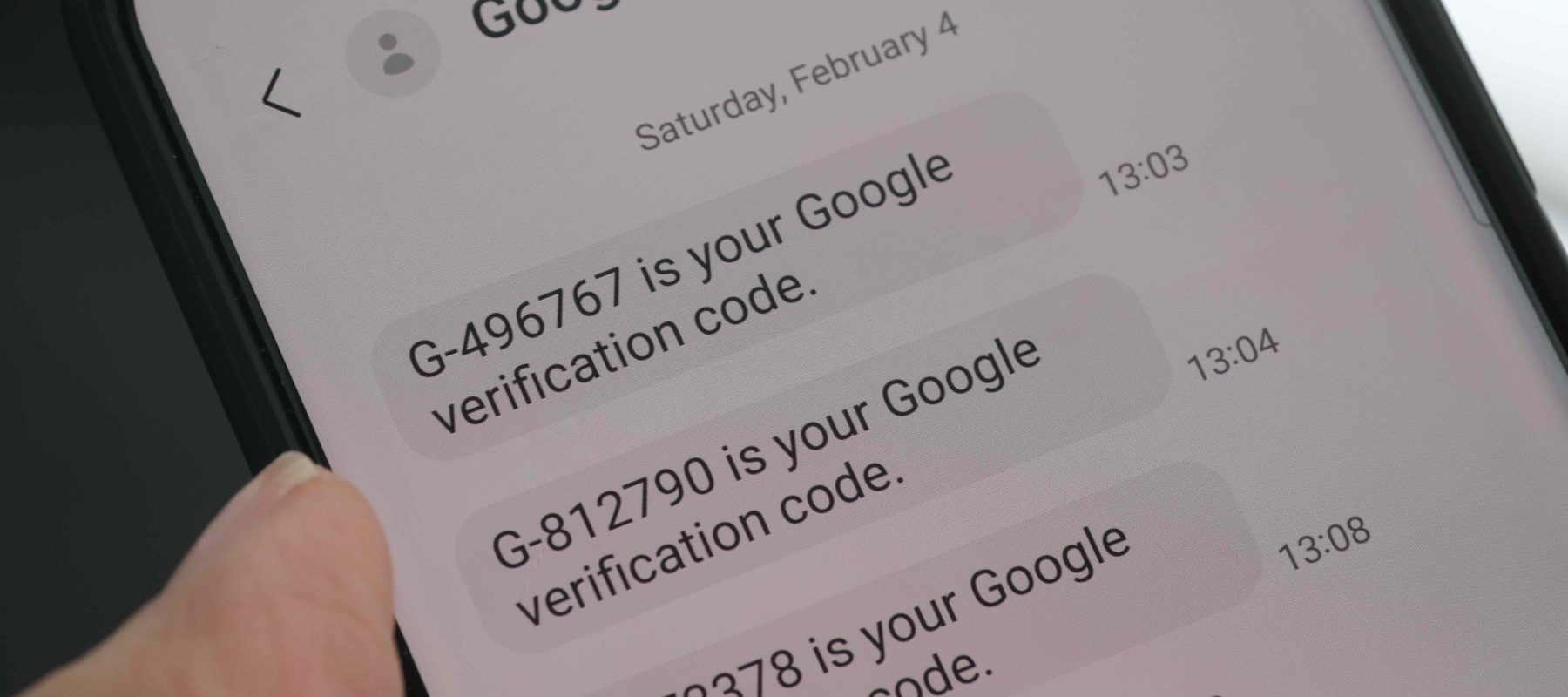 Person holding phone with Google Verification code messages