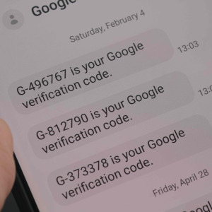 Person holding phone with Google Verification code messages