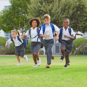 A group of young private school students running together.