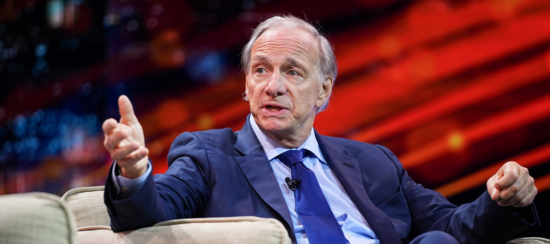 Ray Dalio argues passionately from a chair on stage