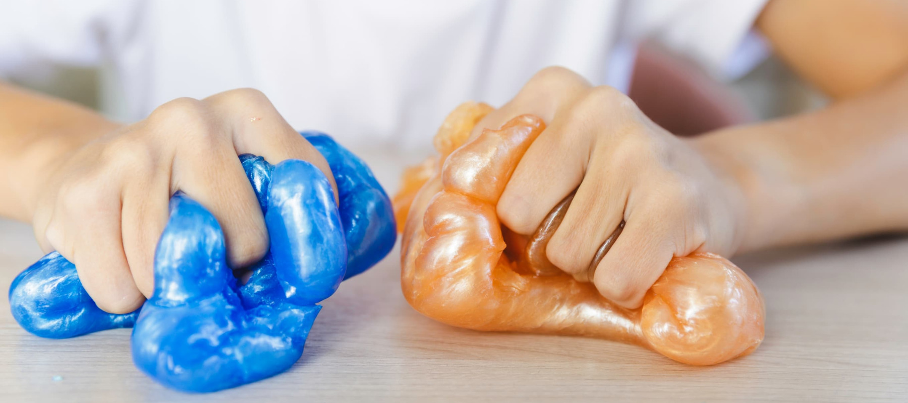 A photo of a man squishing blue and orange slime