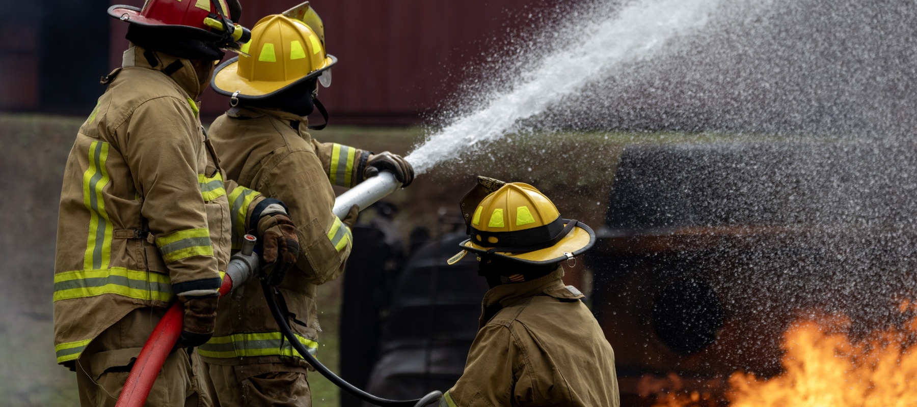 Three firefighters put out a fire at a residential building.