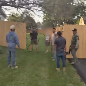 A photo of contractors hammering down a fence