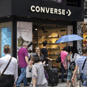 Shoppers are captured walking past a Converse shoe store.