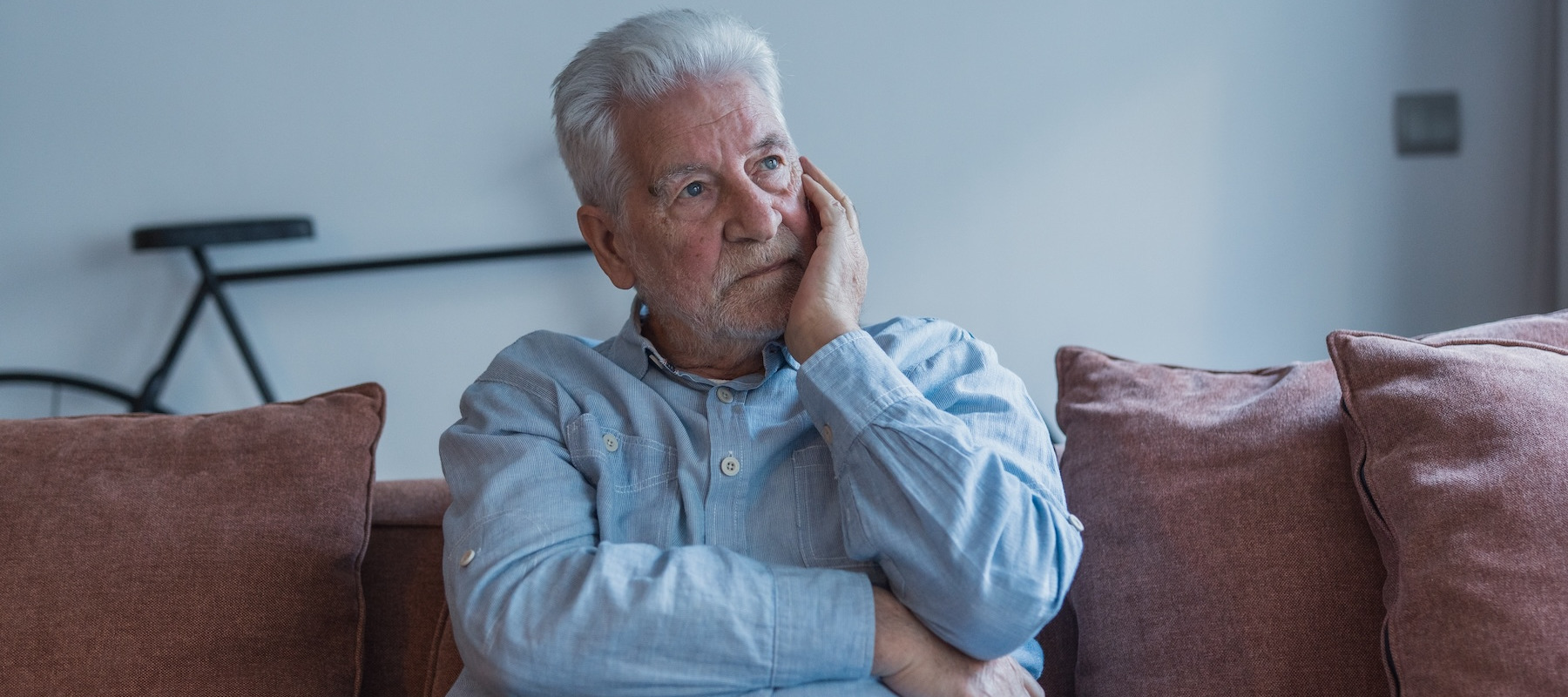 Stressed older man sitting on the couch.