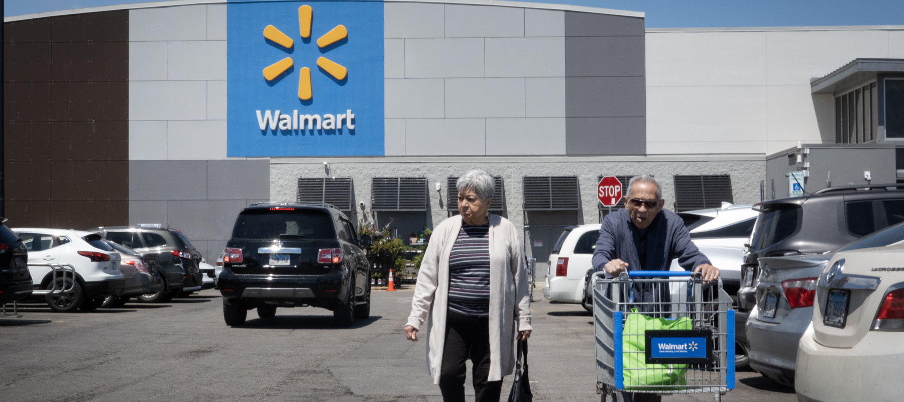 An elderly couple walks through a Walmart parking lot in Chicago, Illinois.
