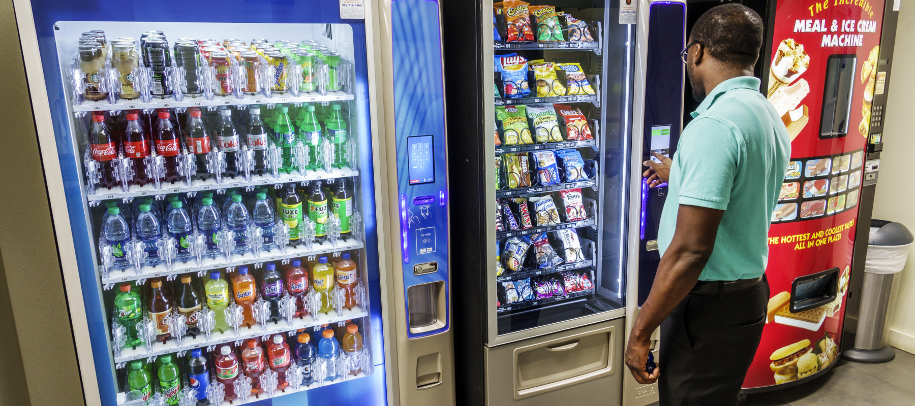 A man is captured purchasing an item at a vending machine.