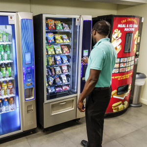 A man is captured purchasing an item at a vending machine.