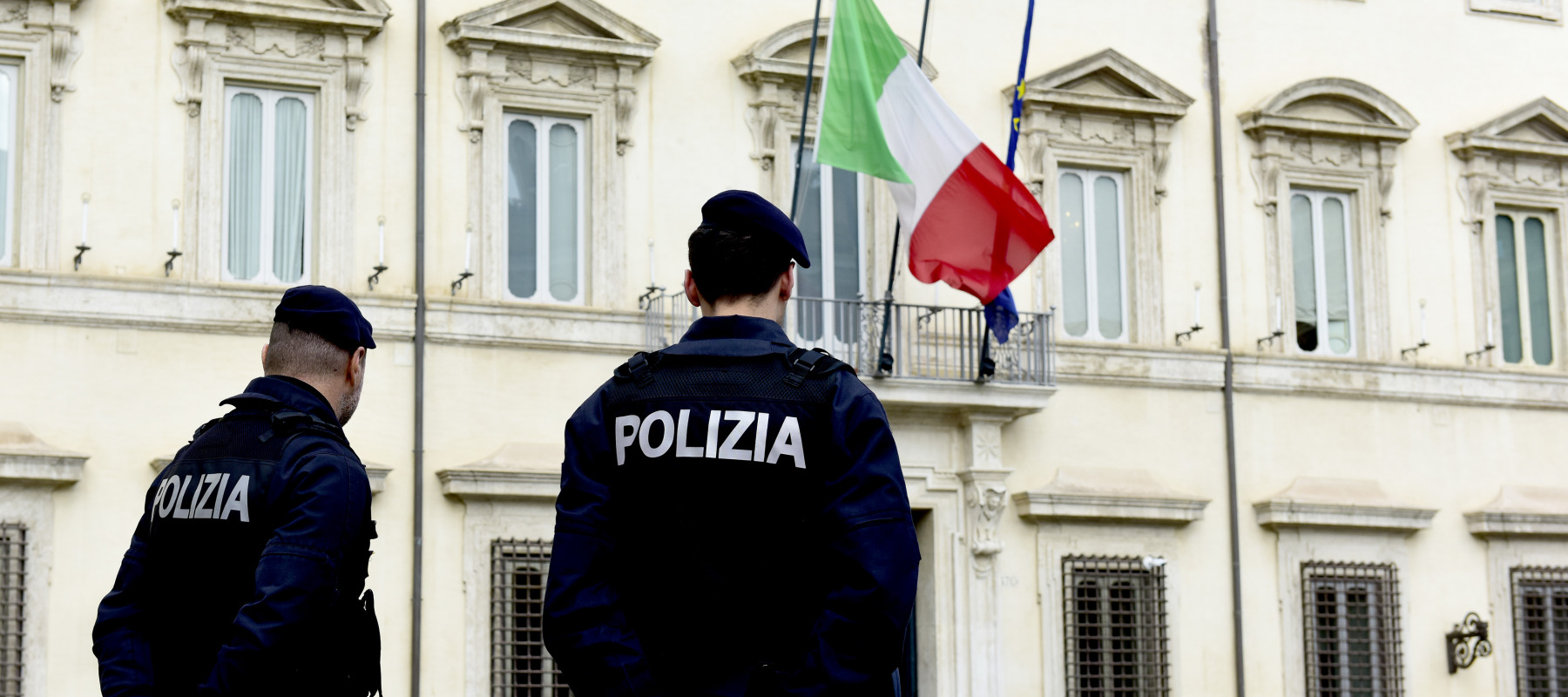 Italian police officers stand in front of the entrance to Palazzo Chigi.